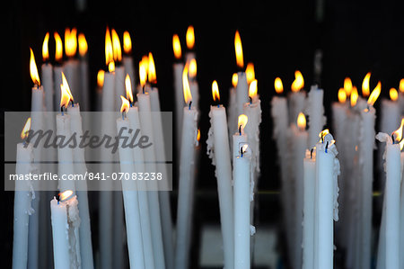 Altar candles in the Cave where Bernadette Soubirous had her Marian apparitions of our Lady of Lourdes in the French town of Lourdes, Hautes-Pyrenees, France, Europe