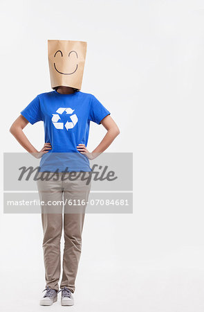 Young woman with smiley face paper bag over her head