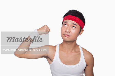 Skinny athlete showing bicep