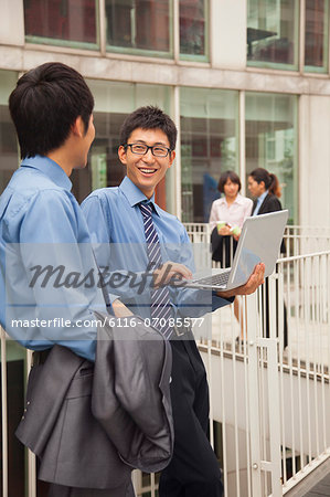 Businessmen working outside with laptop