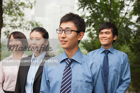 Young business people in the park, portrait