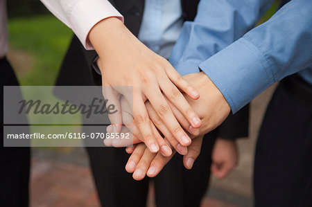 Business people putting their hand together as sign of team working