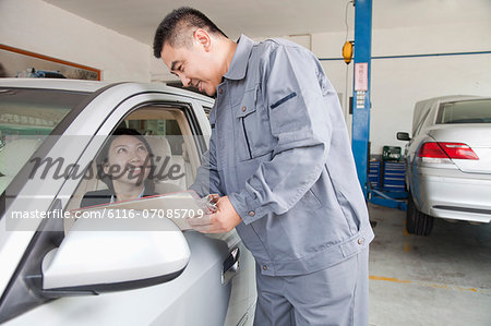 Mechanic Explaining to Businesswoman