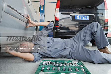 Mechanic Working on Underside of Car