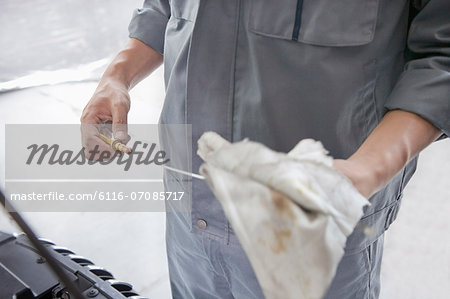 Mechanic Wiping Down Dipstick