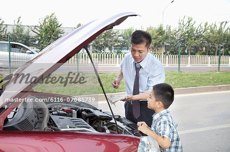 Father and Son Check the Oil on Their Car