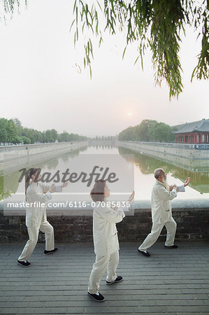Three Chinese People Practicing Tai Ji