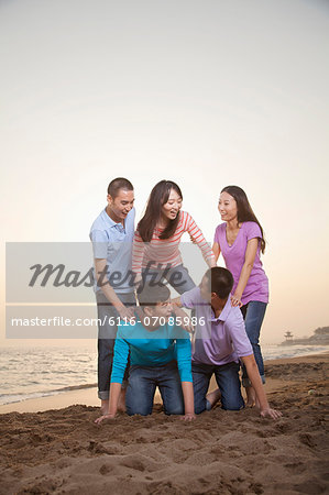 Group of Friends Making Human Pyramid on the Beach