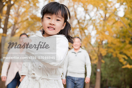 Grandparents and granddaughter in park