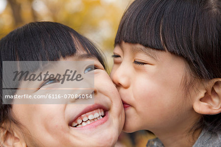 A girl kissing her older sister