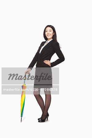 Businesswoman posing with closed umbrella