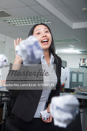 White-collar worker throwing paper in office