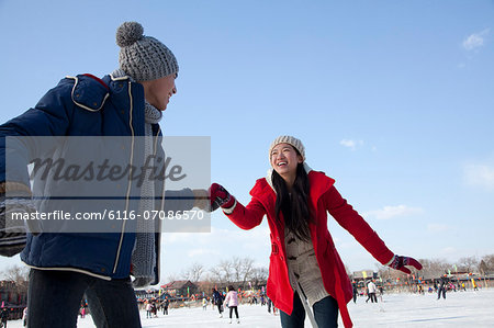 Young couple skating at ice rink