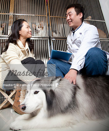 Women with pet dog talking to veterinarian