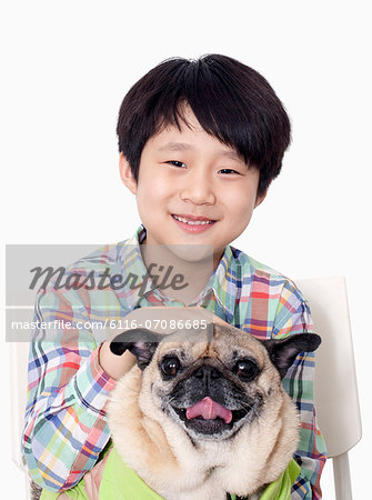 Portrait of Boy holding pet pug