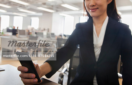 Young Businesswoman using her phone at the office