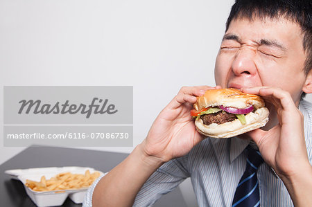 Young businessman enjoying a burger