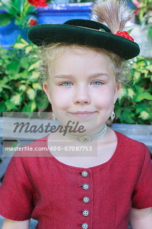 Portrait of a little girl with hat in traditional Bavarian dirndl