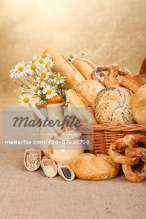Composition of various baked products in basket on rustic background