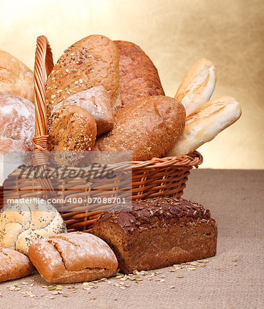 Various breads in basket on canvas tablecloth