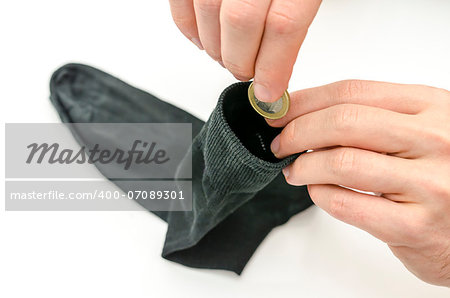 Top view of male hand putting Euro coin into a sock.