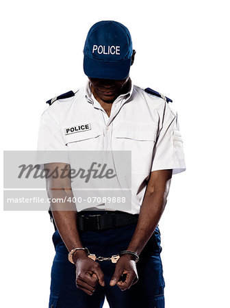 Hand cuffed police officer with head down standing on white isolated background