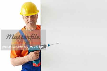 Builder in helmets with a drill