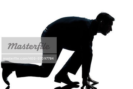 one caucasian man in starting block posture ready to run full length silhouette in studio isolated white background