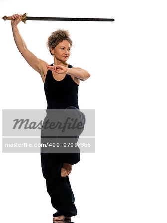 mature woman praticing tai chi chuan with sword in studio on isolated white background