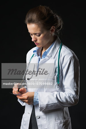 Doctor woman writing prescription isolated on black