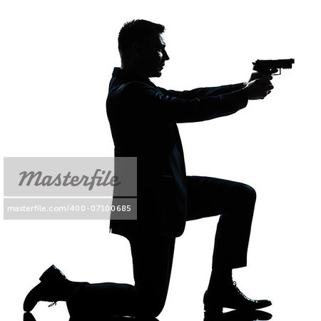 one caucasian spy criminal policeman detective man aiming shooting gun  full length silhouette in studio isolated white background