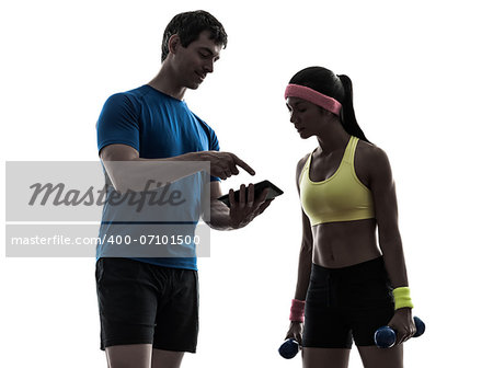 one  woman exercising fitness workout with man coach using digital tablet  in silhouette  on white background