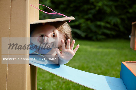 Boy playing in cardboard playhouse, Munich, Bavaria, Germany