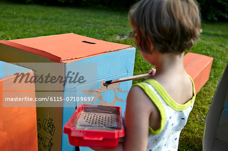 Girl painting cardboard box, Munich, Bavaria, Germany