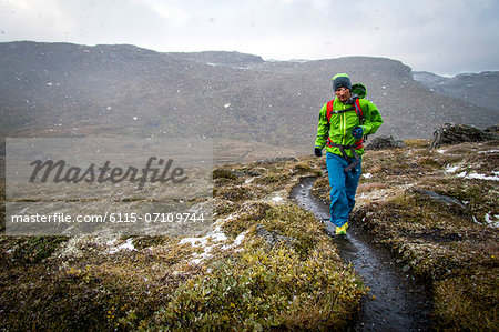 Man speed hiking along snowcapped trail, Norway, Europe