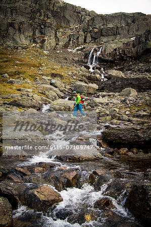 Man speed hiking along mountain stream, Norway, Europe