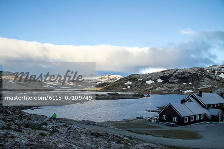 Settlement in a fjord, hiker in foreground, Norway, Europe