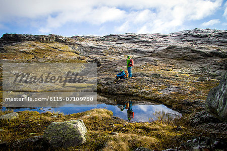 Two hikers take a rest at mountain lake, Norway, Europe
