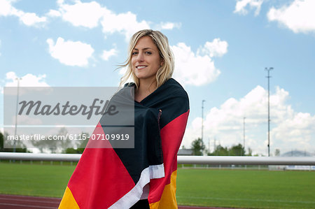 Female soccer fan wrapped in German flag, Munich, Bavaria, Germany