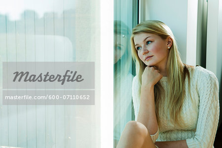 Young Woman Looking out Window, Mannehim, Baden-Wurttemberg, Germany