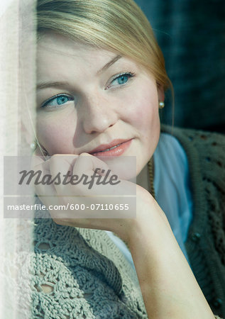 Young Woman Looking out Window, Mannehim, Baden-Wurttemberg, Germany