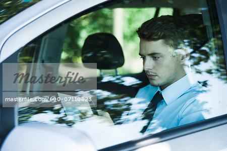 Businessman working on Tablet Computer in Car, Mannheim, Baden-Wurttemberg, Germany