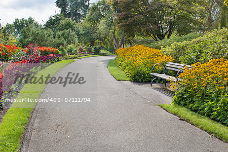 Neighborhood Public Parks Lined with Colorful Flowers Trees and Shrubs with Park Bench