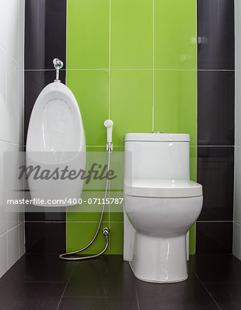 Toilet in gray and green tiled bathroom