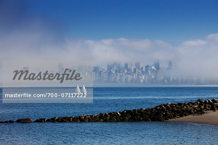 View of harbour and skyline with sailboats in fog, Vancouver, British Columbia, Canada