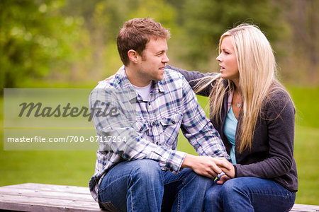 Young Couple Sitting on Picnic Table, Scanlon Creek Conservation Area, Bradford, Ontario, Canada