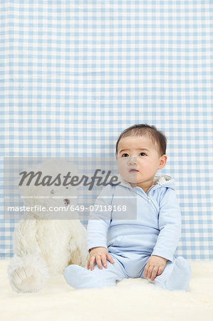 Baby boy sitting with soft toy