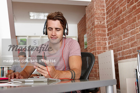 Young man wearing headphones using mp3 player