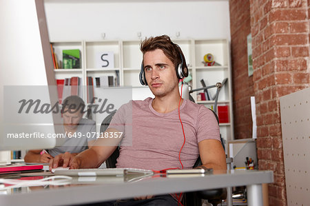 Young man at work wearing headphones