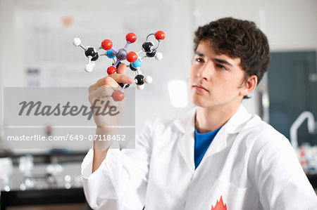 Young man holding molecular model Young man holding molecular model